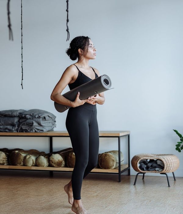 Woman in a powerful yoga pose in a warmly lit studio.